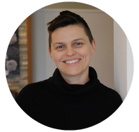 A woman with short, cropped hair is smiling, wearing a black turtleneck. The image is circular.